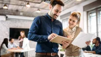 Man with tablet and woman with printed documents