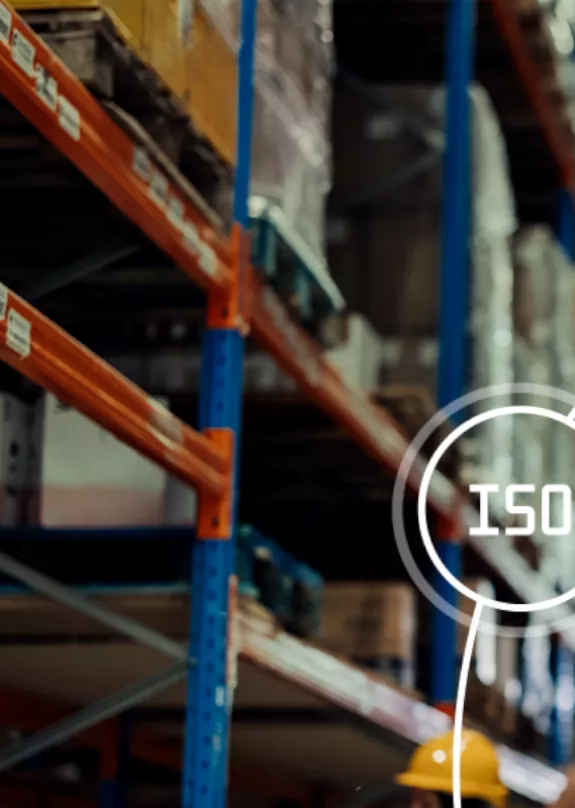 Man wearing a safety helmet in a warehouse with a clipboard